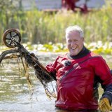 Un plongeur repêche une trottinette dans un étang à l'occasion du Clean-Up-Day. IGSU